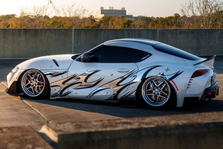 Crafting Captivating Headlines: Your awesome post title goes here Sleek sports car with custom graphics parked outdoors, reflecting sunlight, showcasing modern automotive design.